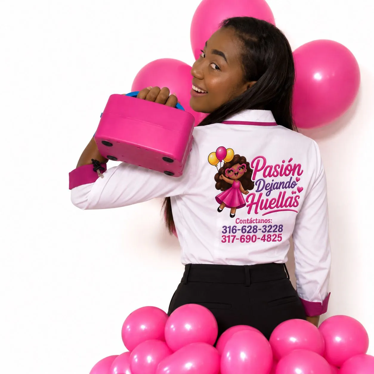 La organizadora de Pasión Dejando Huellas, sonriente, con el uniforme de la marca y globos fucsia